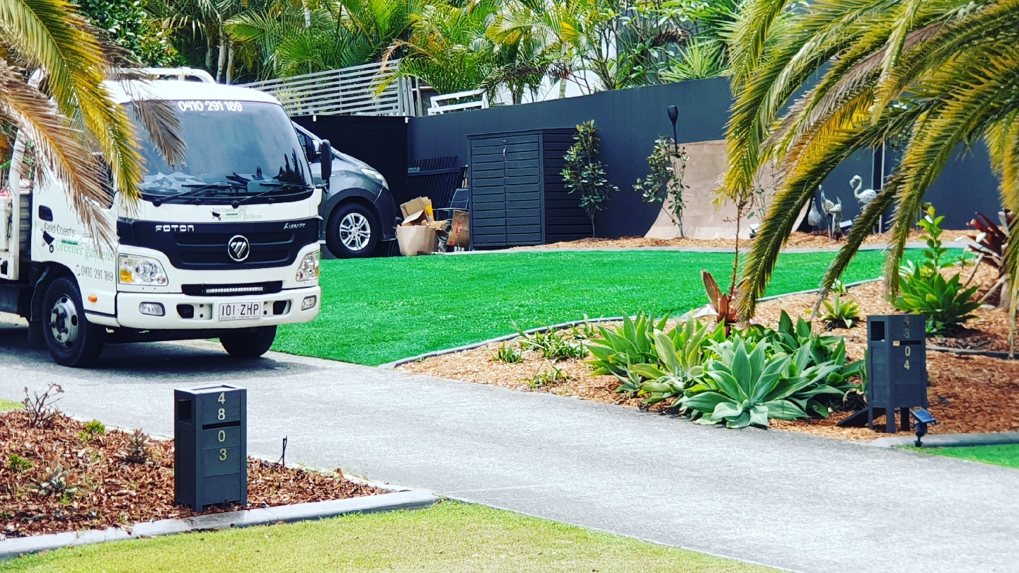 The Gold Coast's Greener Gardens truck, signwritten with the business name and phone number, parked beside new lawn