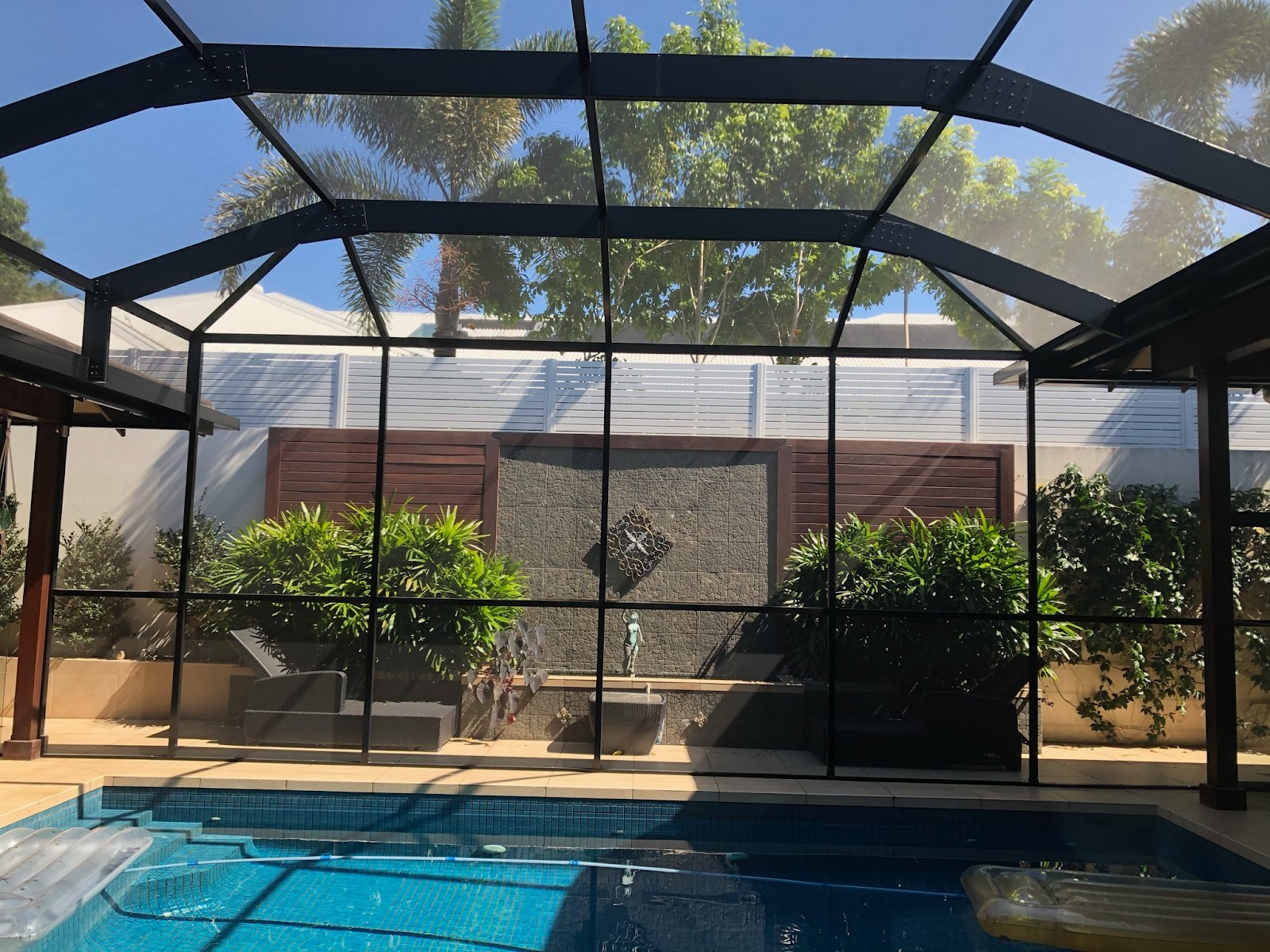 Screened pool enclosure with lush planted surrounds