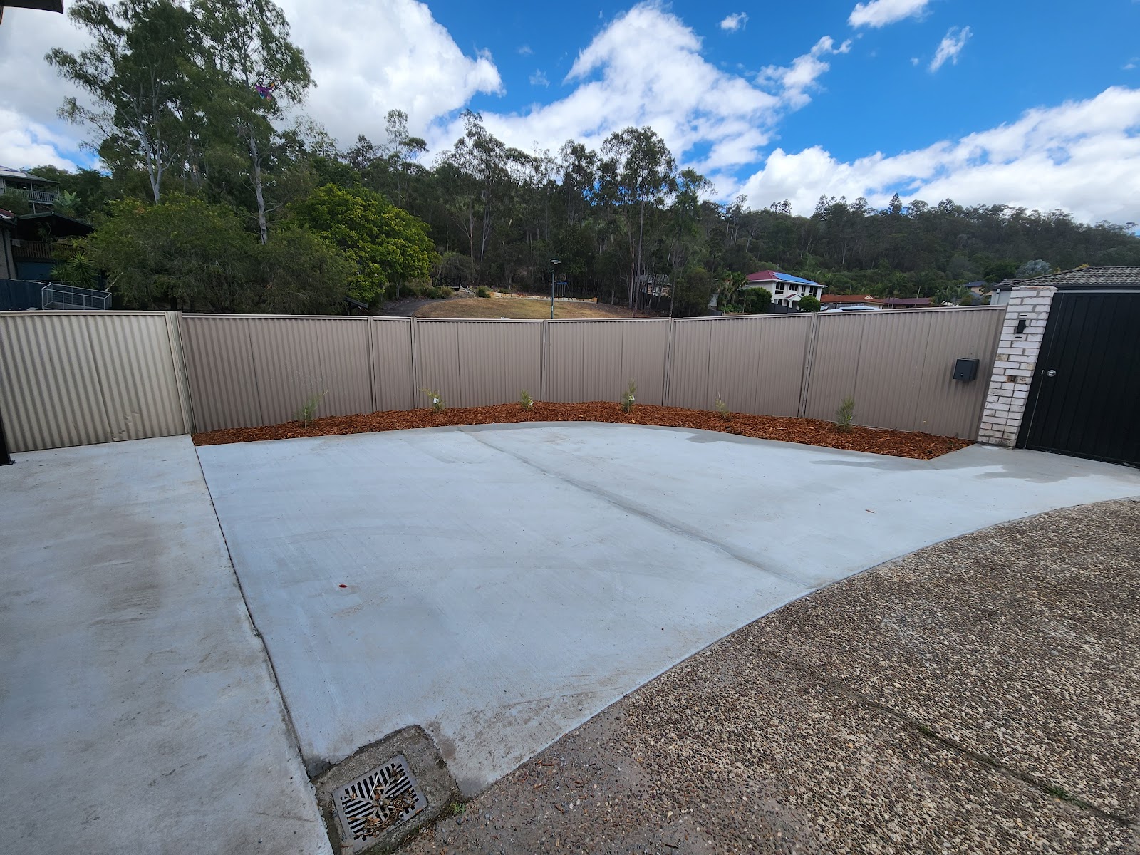 Cleared and levelled backyard with a new concrete slab and Colorbond fence